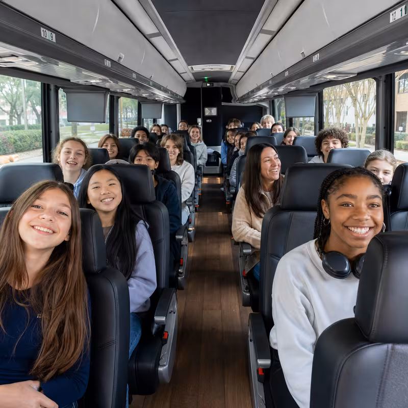 Group boarding a white charter bus for School Transportation transportation in Spokane